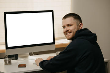 Remote work. A businessman works remotely using an all-in-one computer. A smiling fellow working from home.  
