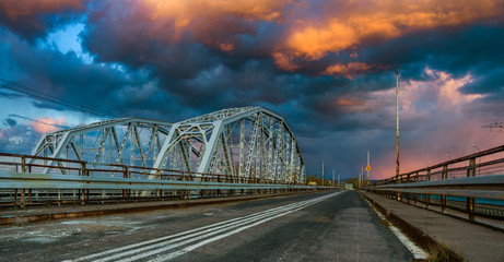 old road bridge next to the truss rail bridge during a dramatic evening storm