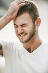 Obraz premium smiling friendly guy with a variety of emotions; a man in a white T-shirt and jeans with a clock on his hand;