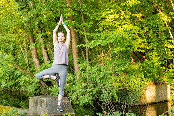 Young woman doing yoga exercises in nature