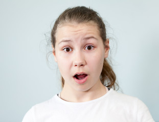 Wide eyes and open mouth, surprise on face of pre-teen girl, background, emotion series