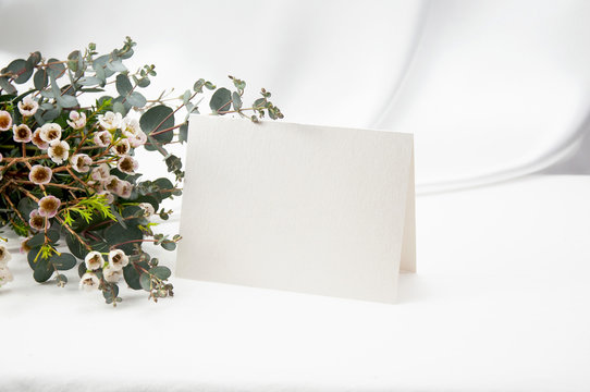Mockup Blank Card, For Name Place, Folded, Greeting, Invitation With Wax Flower And Eucalyptus Leaves On White Background. 