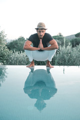 Ethnic Stylish young man prying near a swimming pool