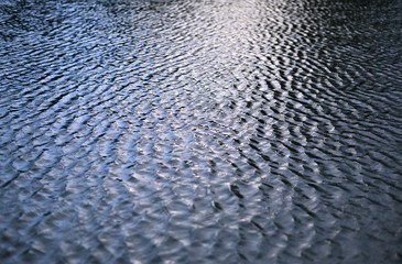 Leichte Wellen auf einem See mit Licht und Schatten von der Sonne als Hintergrund