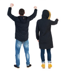 Naklejka premium Back view of two pointing girl in winter jacket.