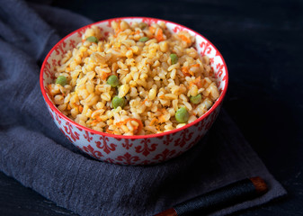 Bulgur porridge with vegetables, green peas and carrots