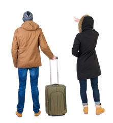 young couple in winter jacket traveling with suitcas.