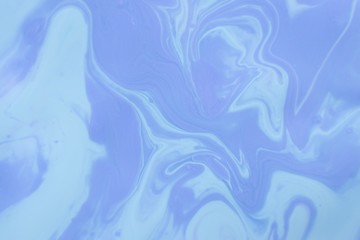 Abstract background of mixed shades of nail polish with a pastel marble pattern. Liquid colorful background paint creative pastel cold blue hue