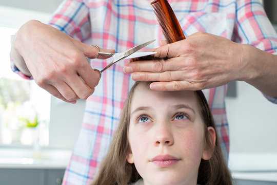 Mother Cutting Worried Daughters Hair At Home During Lockdown