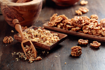 Walnuts in a wooden dish on an old wooden table.