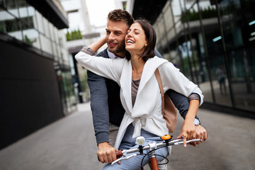 Portrait of happy young couple riding a bike and having fun together outdoor