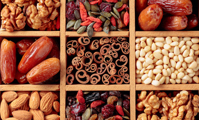 Dried fruits, various nuts and seeds in wooden box.