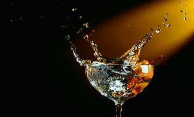 Glass of martini with green olives. Cocktail in glass with splashes.