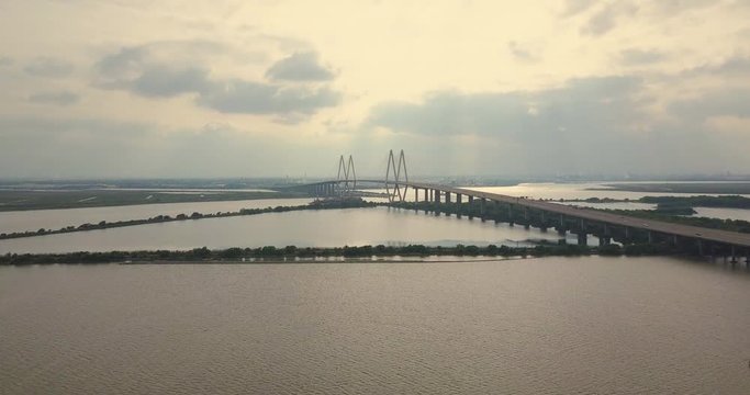 Aerial view of the sunset on the Houston ship channel. Distant view of a cable-stayed bridge.Wide shot, pushing in