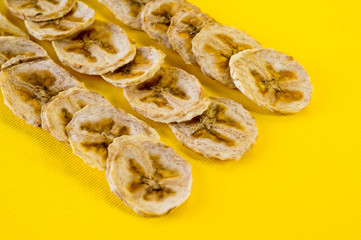 Dried banana chips, sliced in thin circles. Background for healthy and natural nutrition.
