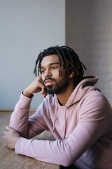 Portrait of sad African American man sitting alone at home 