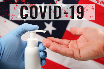 Doctors hand in blue medical glove applying antiseptic alcohol gel on hand without a glove to prevent infections on american flag background. inscription covid-19 and blood drops