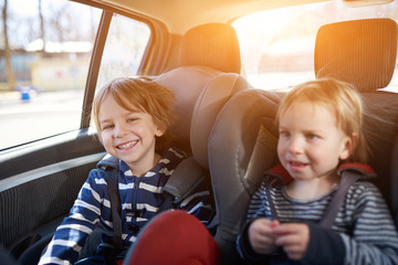 Portrait of pretty boys sitting in car seats. Child transportation safety