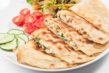 Turkish gozleme tortilla. Tortilla with vegetables on a white plate.