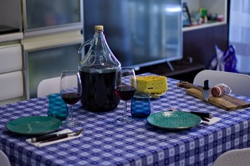 Obraz na płótnie Canvas Table set with dishes, glasses and a bottle of red wine near salami and bread (Pesaro, Italy, Europe)