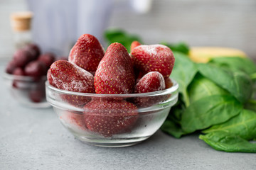 Frozen berries in a glass bowl with banana and spinach