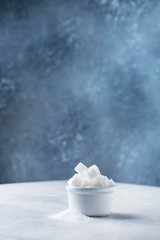 Sugar cubes and grain of sugar