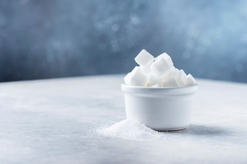 Sugar cubes and grain of sugar