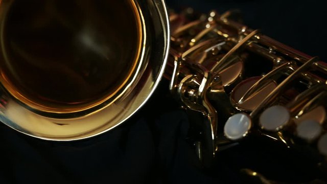 Close up slide shot of a Saxophone camera diving into the horn