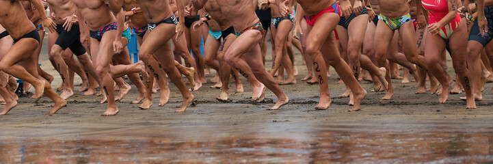 Triathlon athletes ready to startline, racing in swimming, running into the sea
