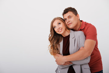 Two friends - a man and a woman hugging and looking forward on a light background. 