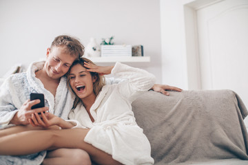 Fototapeta premium young couple watching phone. Couple in love. Love concept. Holidays. Home. 