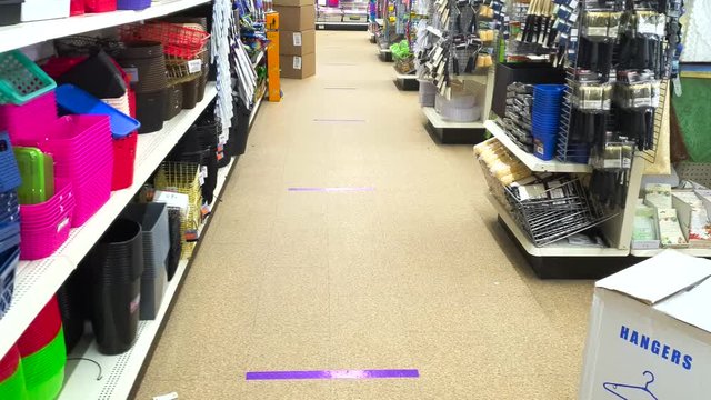 Aisle in store with lines on floor for physical distancing of six feet during Covid Nineteen Coronavirus pandemic