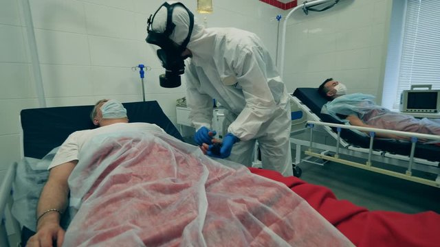 Working doctor treats a patient with ventilator during coronavirus pandemic. Coronavirus, covid-19 patient in intensive care unit at a hospital.