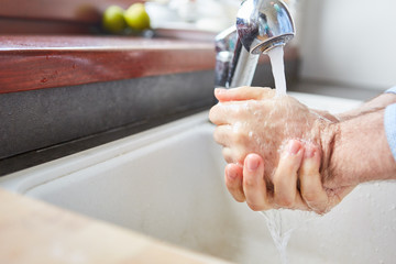 Elderly woman washing hands with soap because of corona virus