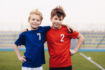 Two happy boys outdoor in sportswear. Children smiling to camera. Kids standing on sports grass field. Sports education for children