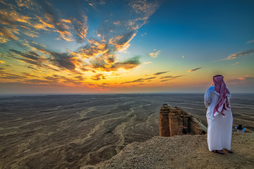 An arab man standing Edge of the world, a natural landmark and popular tourist destination near...