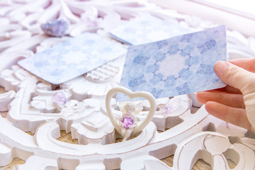 Deck with divination homemade Angel cards on bright white table, surrounded with semi precious...