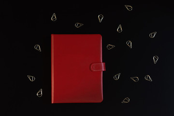 Red notebook on black. Business concept, questions.