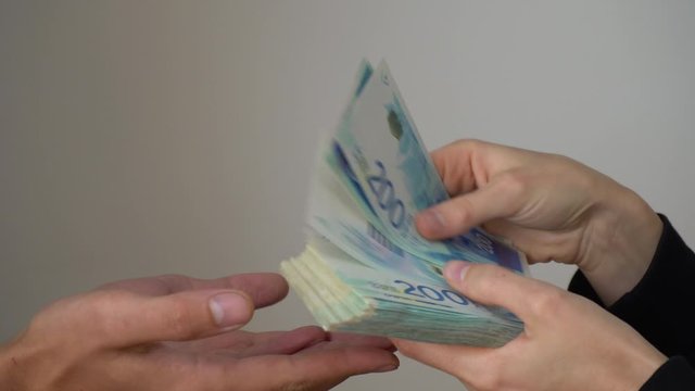 A man gives another man money, Israeli shekels