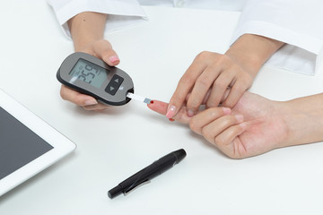 check diabetes. patient with diabetes let doctor put a drop of blood on a test strip into a meter for check blood sugar (glucose) levels results. health care concept