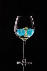 Wine glass with ice different colors on a black background.