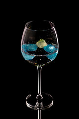Wine glass with ice different colors on a black background.