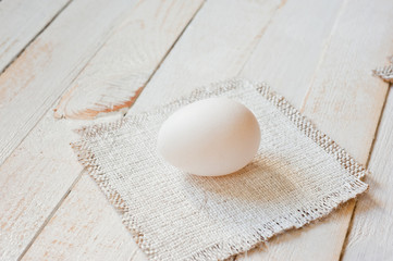 White chicken eggs lying on a white painted wooden surface. Background for livestock products.