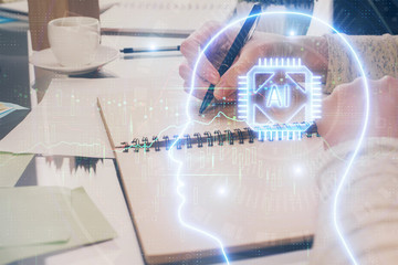Double exposure of writing hand on background with brain hologram. Concept of learning.