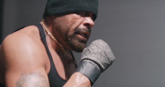 Tan, muscular, bearded man shadow boxing and getting hyped.