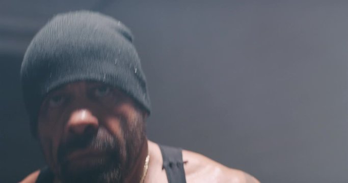 Muscular, tan, bearded man trains with footwork and fists.