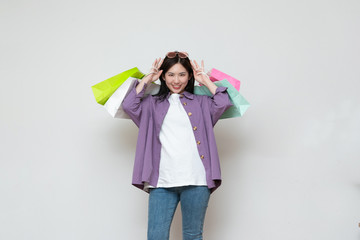 A young asian woman with a shopping bag in her hand