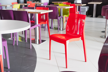 Plastic red chair at an empty fast food cafe. Concept of quarantine, lockdown, closed business and catering