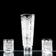 Set of crystal glasses and a vase on a dark background