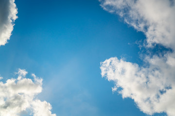 Obraz premium Background nature clear clean blue sky soft clouds beautiful dramatic cloudscape summer sun ray light presents beautiful day life after storm. use as overlay effect or frame with center copy space 